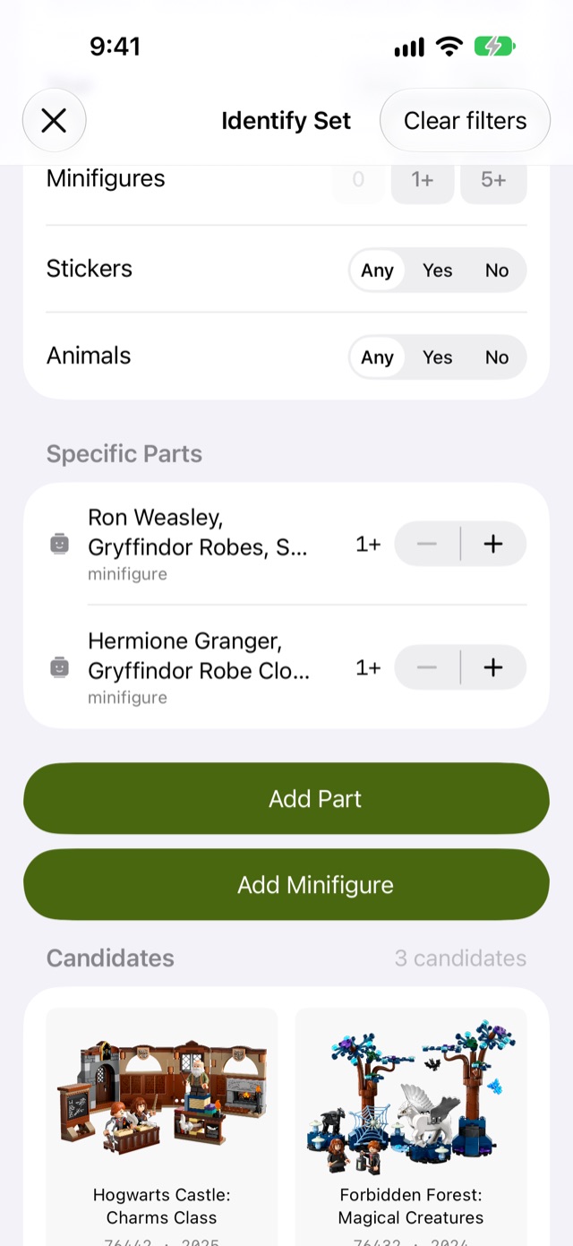 Afolio's Identify Set on iPhone with two minifigure filters, Ron Weasley in Gryffindor robes with short legs and Hermione Granger in a closed Gryffindor robe, listing 3 candidate sets including Hogwarts Castle: Charms Class and Forbidden Forest: Magical Creatures.